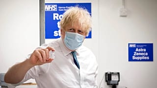 UK Prime Minister Boris Johnson holds a vial of the Oxford AstraZeneca COVID-19 vaccine during a visit of a coronavirus vaccination centre in London, Jan. 25, 2021