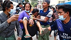 Ein verletzter Demonstrant wird in Mandalay von Helfern weggetragen