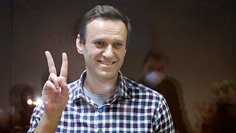Russian opposition leader Alexei Navalny stands in a cage in the Babuskinsky District Court in Moscow, Russia, Saturday, Feb. 20, 2021.