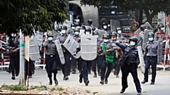 Police charge forward to disperse protesters in Mandalay, Myanmar on Saturday, Feb. 20
