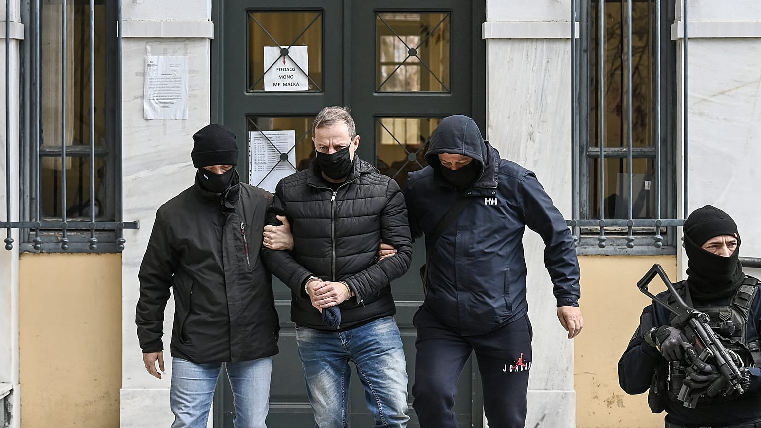 يغادر المدير الفني السابق للمسرح الوطني اليوناني ديميتريس ليجناديس (في الوسط)، برفقة ضباط الشرطة، مكتب قاضي التحقيق في أثينا. 