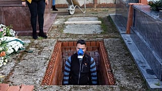 Una foto del 1 aprile 2020: un addetto alla sepoltura prepara una tomba nel cimitero di Zarza de Tajo, nella Spagna centrale