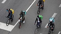 In this Nov. 5, 2020 file photo, food delivery riders stage a protest against the government restriction measures to curb the spread of coronavirus in Milan, Italy.