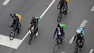 In this Nov. 5, 2020 file photo, food delivery riders stage a protest against the government restriction measures to curb the spread of coronavirus in Milan, Italy.