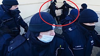 Sarokba szorítanak egy tüntető nőt rendőrök, Varsó, 2021. február 6.
