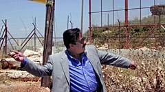 صورة من الارشيف  لممثل المصري يوسف شعبان يلقي حجراً على بوابة فاطمة على الحدود اللبنانية - الإسرائيلية