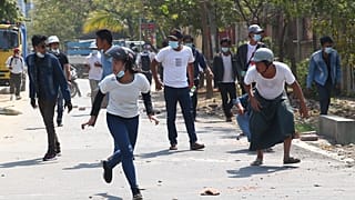Manifestantes fogem de gás lacrimogéneo disparado pela polícia em Mandalay