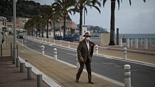 Un résident de la ville de Nice, en France, marche en bord de mer, le 27 février 2021