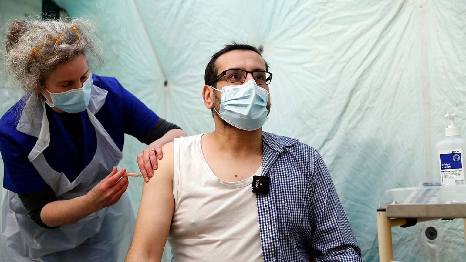 A man receives a dose of the AstraZeneca COVID-19 vaccine at pop up vaccination drive called Vaxi Taxi in Kilburn, London, Feb. 28, 2021. 