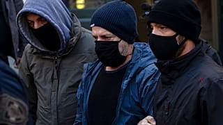 Plain-clothed policemen escort actor-director Dimitris Lignadis