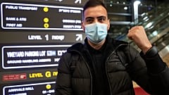 A traveler holds up an electronic monitoring bracelet