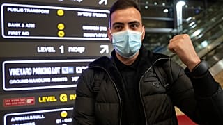 A traveler holds up an electronic monitoring bracelet