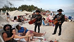 Dos mariachis hablan con turistas en Playa del Carmen, en el estado mexicano de  Quintana Roo.