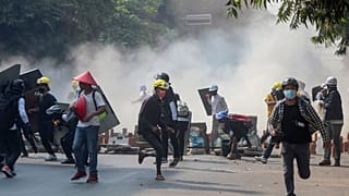 Anti-coup protesters run from teargas and charging riot police and soldiers in Mandalay, Myanmar on Wednesday