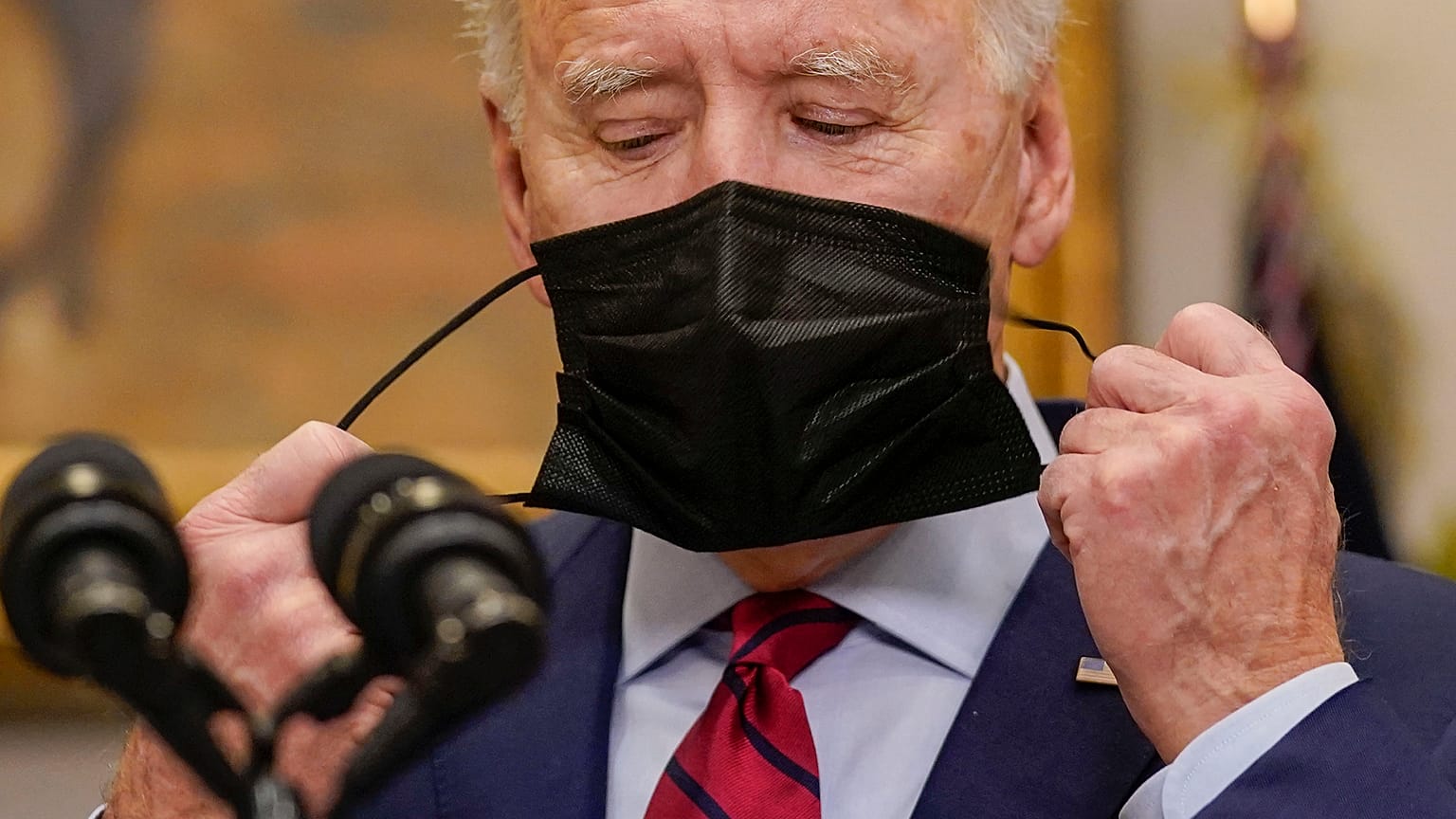 Joe Biden retire son masque, le 27 février 2021, à la Maison blanche, Washington USA