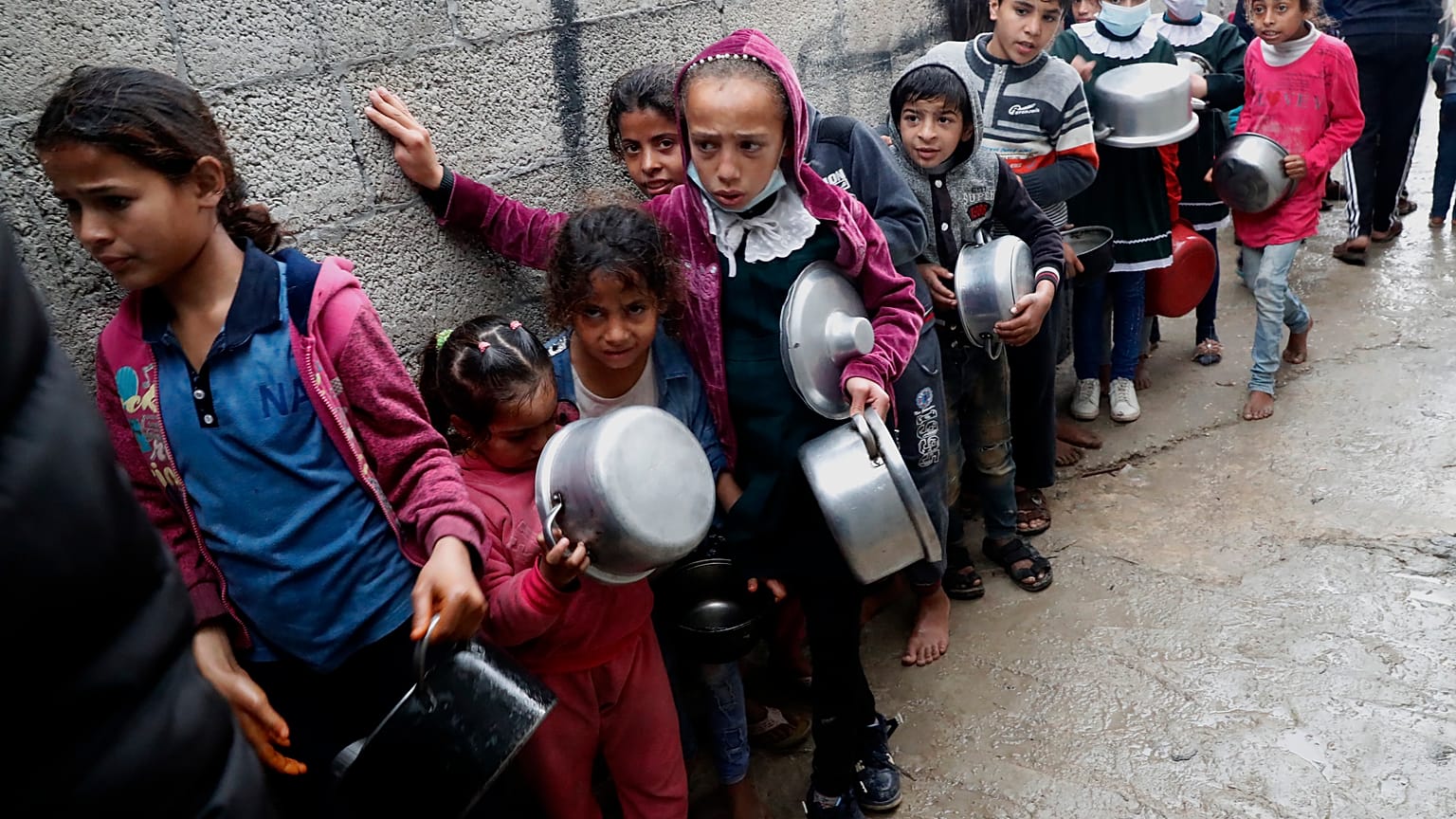 أطفال فلسطينيون ينتظرون تلقي وجبات مجانية في قطاع غزة.  