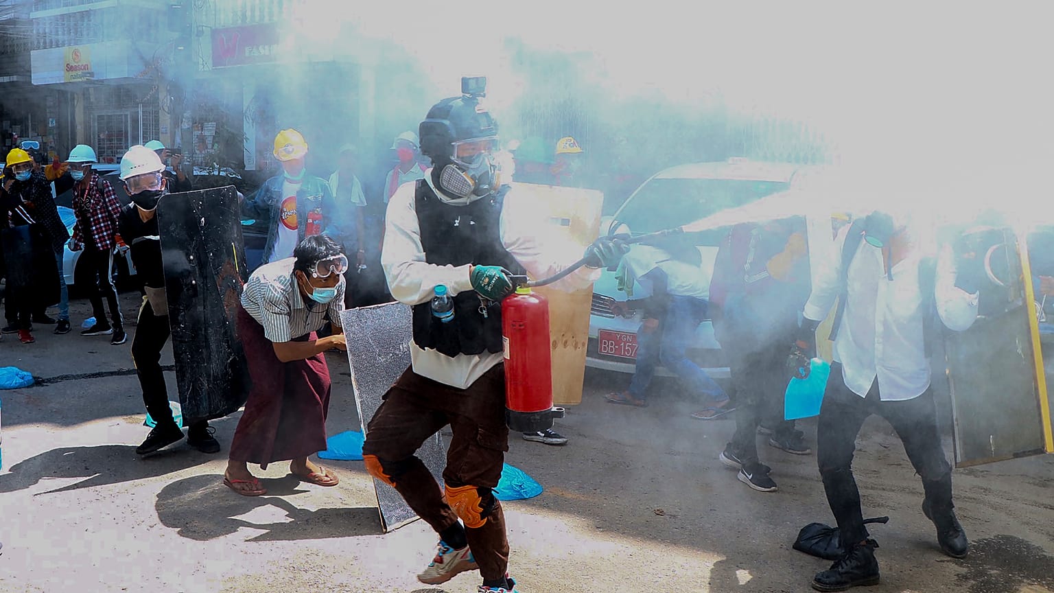 Anti-coup protesters discharge fire extinguishers to counter the impact of the tear gas fired by police during a demonstration in Yangon, Myanmar, March 4, 2021.