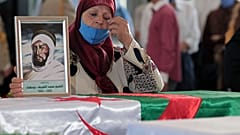 جزائرية تبكي على نعش واحد من 24 جزائريًا تم إعادة بقاياهم بعد إعدامهم في الجزائر العاصمة.
