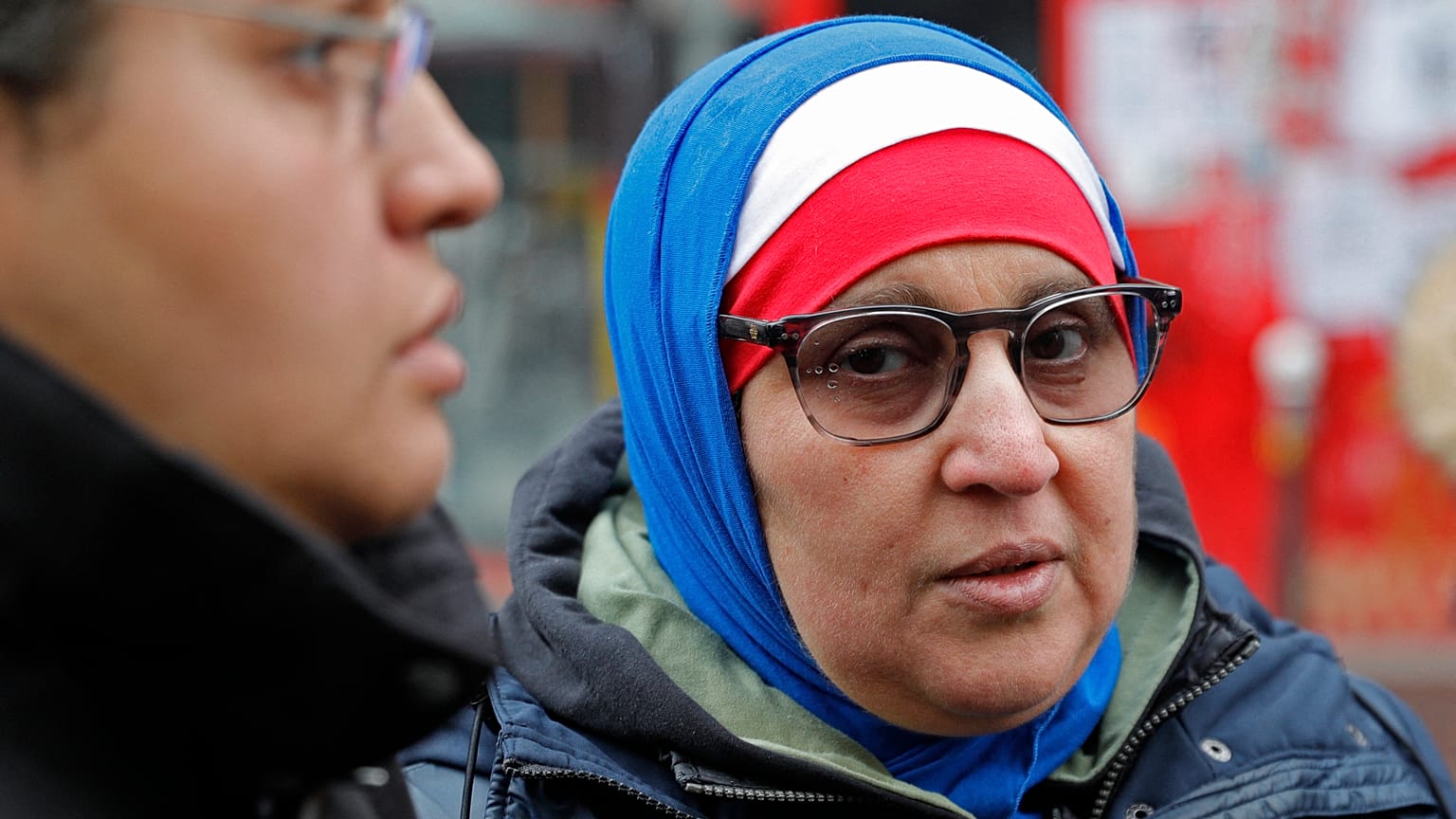 صورة من الارشيف - سيدة  محجبة بالوان العلم الفرنسي، الأزرق والأبيض والأحمر، خلال مسيرة في باريس احتجاجاً على الإسلاموفوبيا.