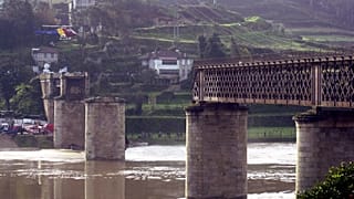 A rescue helicopter circles above the remains of the bridge on March 5, 2001.