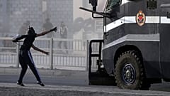 متظاهر بحريني يرمي سيارة للشرطة بقطعة لوح. 2013/03/15
