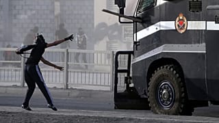 متظاهر بحريني يرمي سيارة للشرطة بقطعة لوح. 2013/03/15