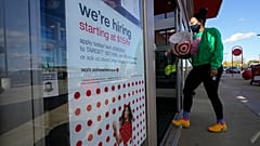 In this Sept. 30, 2020, file photo, a passerby walks past a hiring sign while entering a Target store in Westwood, Mass. 