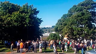 People gather on high ground in Whangarei, New Zealand, as a tsunami warning is issued
