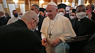 Pope Francis is greeted by a clergyman upon his arrival at the Syro-Catholic Cathedral of Our Lady of Salvation (Sayidat al-Najat) in the capital Baghdad