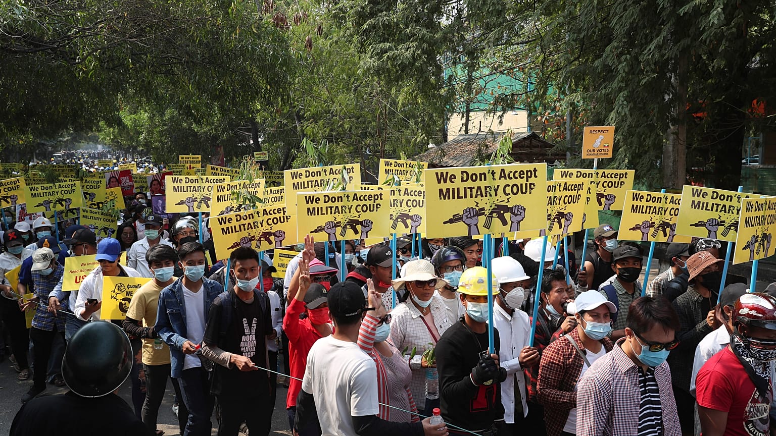 Demonstrators wearing helmet and face mask march during an anti-coup protest in Mandalay, Myanmar, Saturday, March 6, 2021.