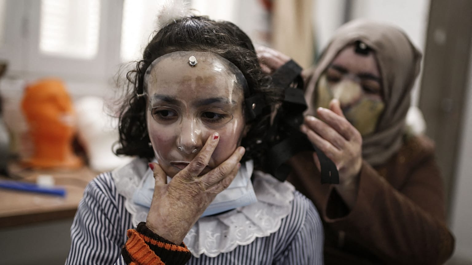 مرام تلبس القناع وتبدو والدتها في الخلفية 