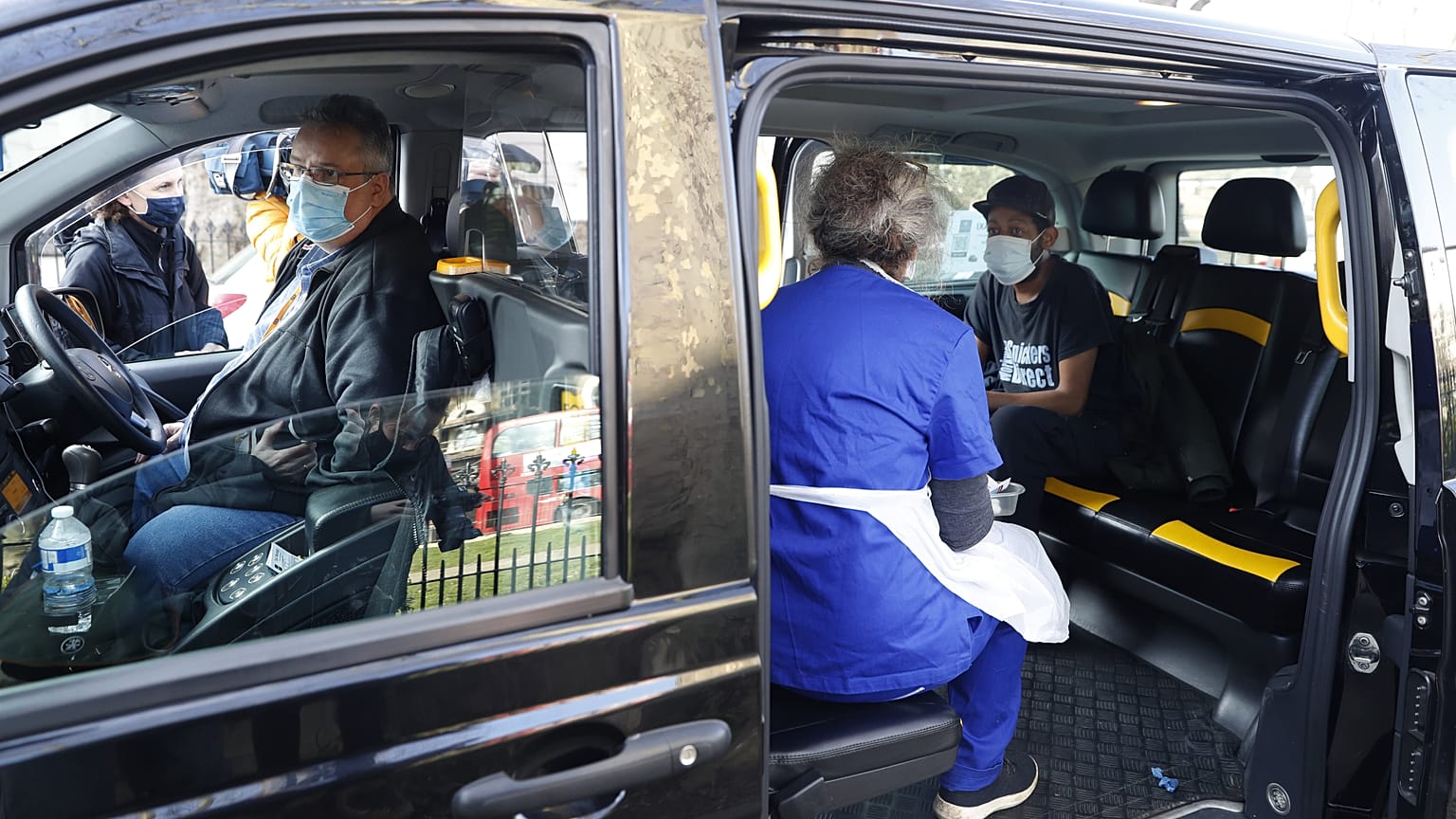 Dr Tamara Joffe prepares to give a Covid-19 jab to Leslie Reid in the back of a London Taxi cab during the pilot project of pop up vaccination drive 'Vaxi Taxi'.