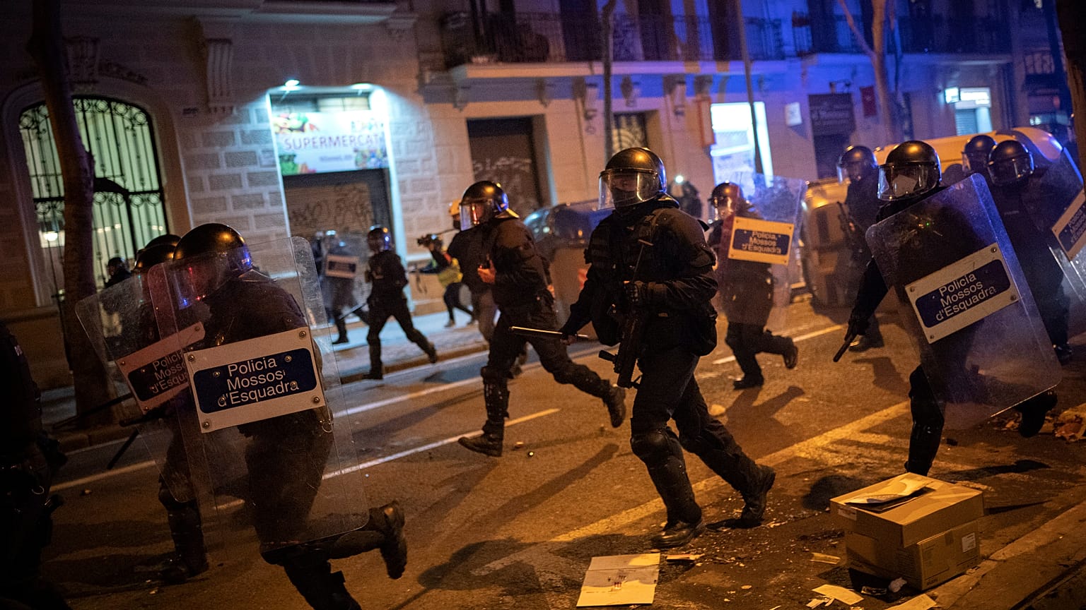 FILE PHOTO: Police officers run during clashes following a protest condemning the arrest of rap singer Pablo Hasel in Barcelona, Spain, Tuesday, Feb. 23, 2021.
