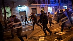FILE PHOTO: Police officers run during clashes following a protest condemning the arrest of rap singer Pablo Hasel in Barcelona, Spain, Tuesday, Feb. 23, 2021.