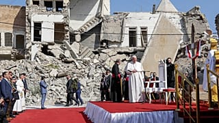 Pope Francis, surrounded by shells of destroyed churches, arrives to pray for the victims of war at Hosh al-Bieaa Church Square, in Mosul, Iraq.