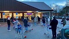 Customers wait for the opening of a branch of the German discounter 'Aldi' in Hamburg, Germany, Saturday, March 6, 2021.