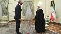 Iranian President Hassan Rouhani, right, and Irish Foreign Minister Simon Coveney greet at the start of their meeting in Tehran, Iran, Sunday, March 7, 2021.