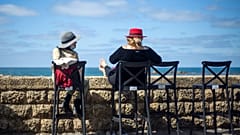 Women sit in a caffe-bar overlooking the Mediterranean Sea as restrictions are eased following months of shutdowns, in Tel Aviv, Israel, Sunday, March 7, 2021