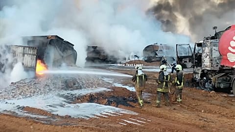 Civil Defense workers extinguish burning oil tanker trucks after a suspected missile strike around the towns of Jarablus and al-Bab, Syria
