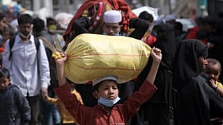 لاجئون من الروهينغا يحملون أمتعتهم أثناء مغادرتهم مخيم الروهينجا للاجئين في جامو في 7 آذار / مارس 2021.