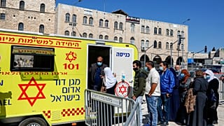 فلسطينيون يصطفون للحصول على لقاح ضد فيروس كورونا خارج عيادة متنقلة.