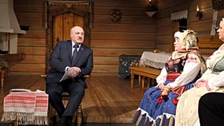 Belarusian President Alexander Lukashenko, sits on stage talking to a group of actors during his visit to the Yanka Kupala National Theater in Minsk, Friday, Feb. 19, 2021