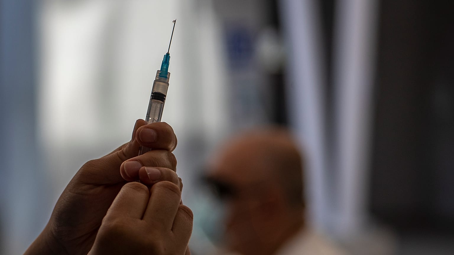 عامل من الجهاز الطبي يحضر جرعة من لقاح "سينوفارم" 