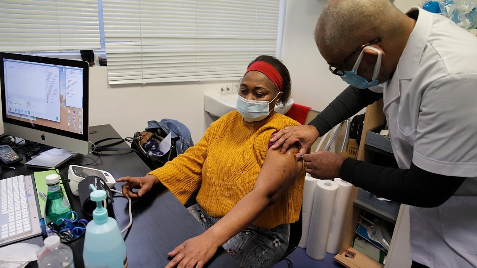 Family doctor Joel Valendoff administrates the AstraZeneca COVID-19 vaccine to a woman at his office, Thursday, Feb. 25, 2021 in Paris.