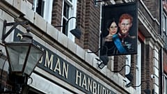 A sign showing Britain's Prince Harry and his wife Meghan, hangs outside the Duke of Sussex pub near Waterloo station, London, Tuesday March 9, 2021