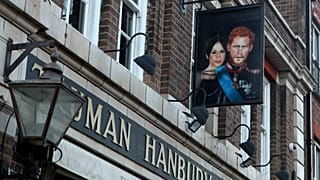 A sign showing Britain's Prince Harry and his wife Meghan, hangs outside the Duke of Sussex pub near Waterloo station, London, Tuesday March 9, 2021