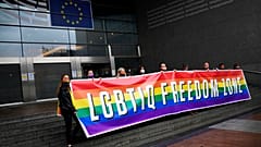 Activists hold a rainbow banner in front of the European Parliament in Brussels on Tuesday ahead of the debate.