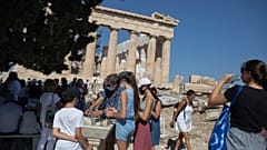 Tourists fill up their water bottles, in front of the ancient temple of Parthenon at Acropolis Hill, in Athens, July 31, 2020.