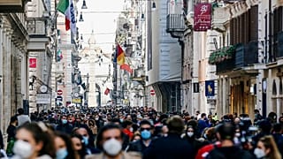 People crowd Via del Corso shopping street in Rome