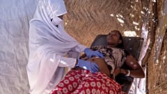 قابلة سودانية تفحص امرأة حامل في عيادة تديرها منظمة أطباء بلا حدود في مخيم أم ركوبة للاجئين في القضارف، شرق السودان - 2020